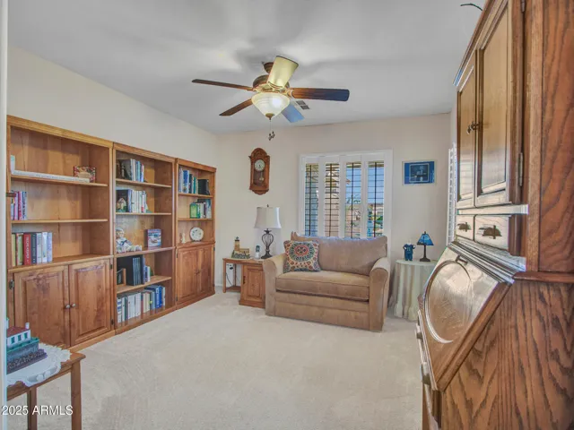 Versatile den ideal for a home office, reading room, or hobby space. Soft carpet, ceiling fan, and built-in storage add comfort and flexibility.