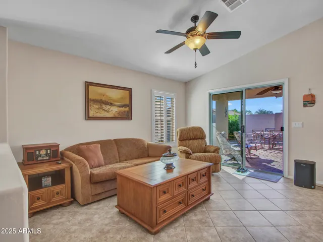 Comfortable family room featuring tile flooring, ceiling fan, and sliding glass doors opening to the covered patio. Designed for indoor-outdoor living in Buckeye.
