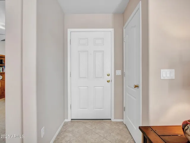 Light-filled foyer with tile flooring and neutral finishes sets a warm tone upon entry. The layout offers a smooth transition into the living spaces.