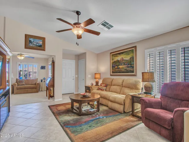 Living space filled with natural light from plantation shutters, featuring an open feel and easy flow to the outdoor patio for indoor-outdoor living.