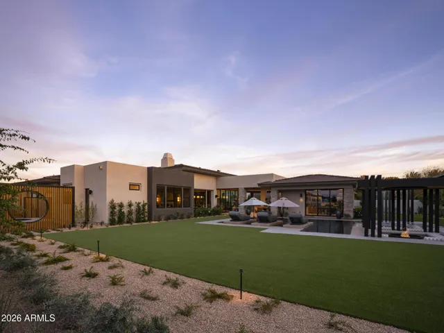 Entertainer's Dream Backyard! Custom infinity edge pool with Waterfall Feature, sunken sitting area with firepit, covered outdoor kitchen and living space! Established mature landscape makes you feel if you have stepped into your own private Resort!