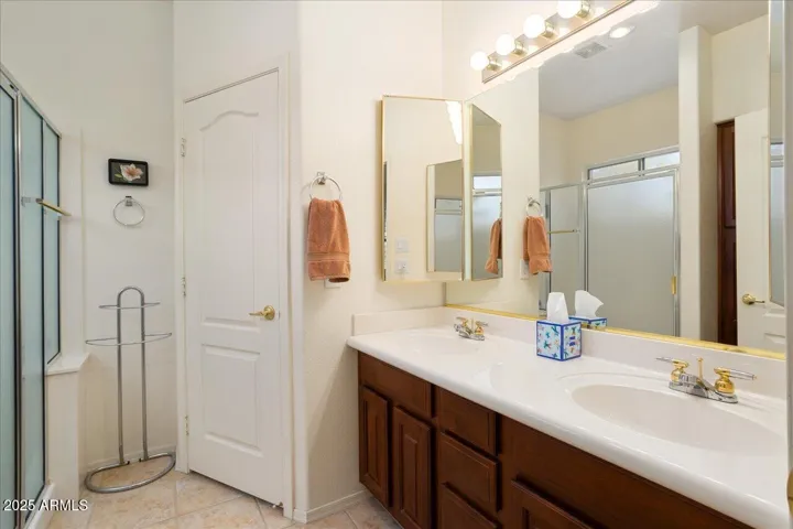 This bath has dual sinks, a large walk-in shower, and a private water closet.