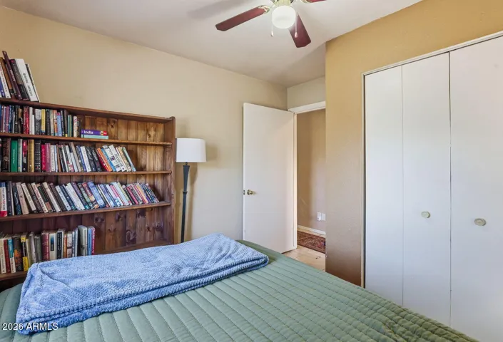 Guest bedroom with bookshelf storage and closet. Ideal for guests or home office in Hackberry AZ home.
