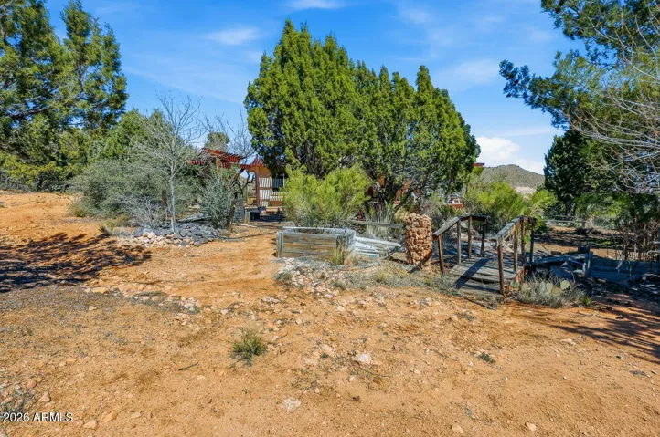 Charming garden area with small bridge, trees and natural landscaping creating a peaceful outdoor retreat in Hackberry AZ.
