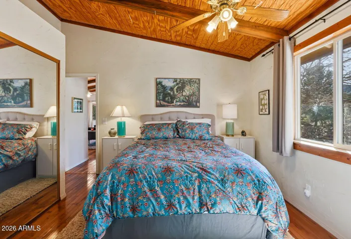 Spacious primary bedroom with vaulted wood ceiling, large window and peaceful desert views in Hackberry AZ near Kingman.