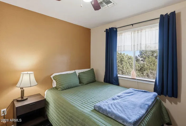 Guest bedroom with window views of desert landscape and trees. Relaxing space in Hackberry Arizona near Kingman.