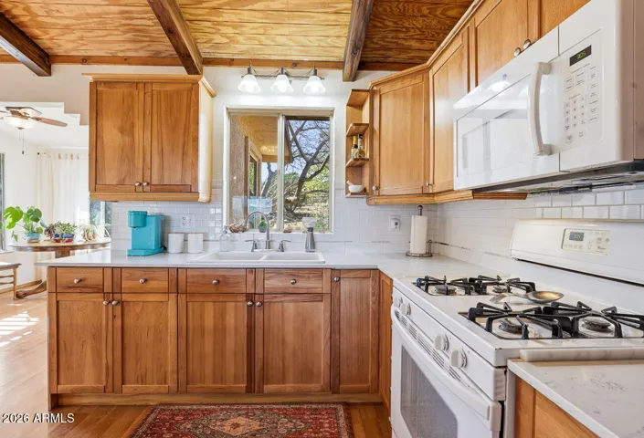 Kitchen with gas range, wood cabinets and subway tile backsplash. Practical cooking space in Hackberry Arizona.