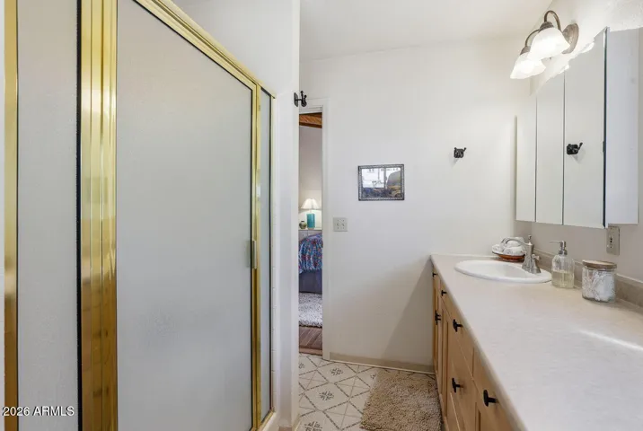 Bathroom with shower and vanity storage. Practical layout in this peaceful Hackberry AZ retreat.