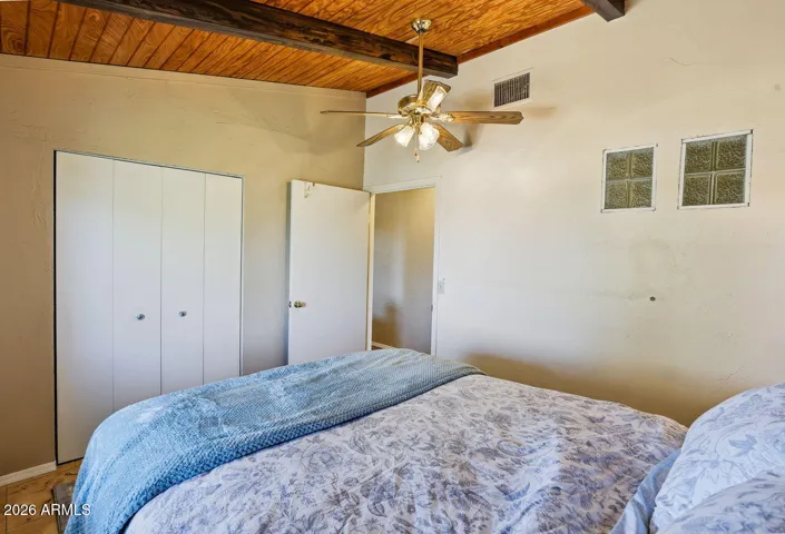 Bedroom with built-in closet storage and wood ceiling detail. Comfortable guest space in Hackberry AZ desert retreat.