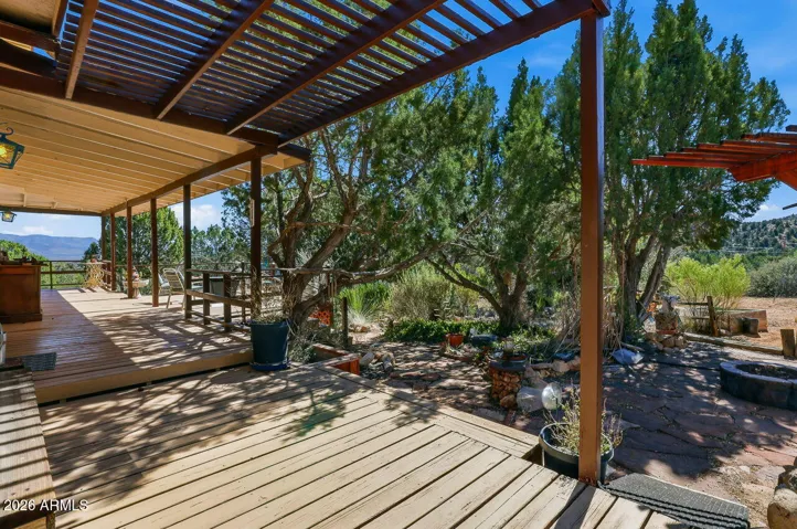 Covered deck with wood beams overlooking trees and mountains. Relaxing outdoor living in Hackberry AZ near Kingman.