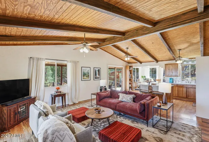 Vaulted wood ceilings and bright windows highlight this inviting living room in a peaceful Hackberry Arizona setting.