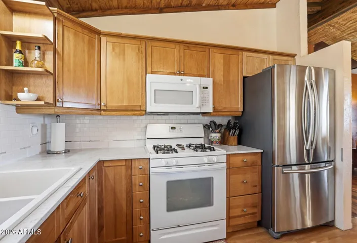 Kitchen with stainless refrigerator, gas stove and wood cabinetry. Comfortable everyday living in Hackberry AZ near Kingman.