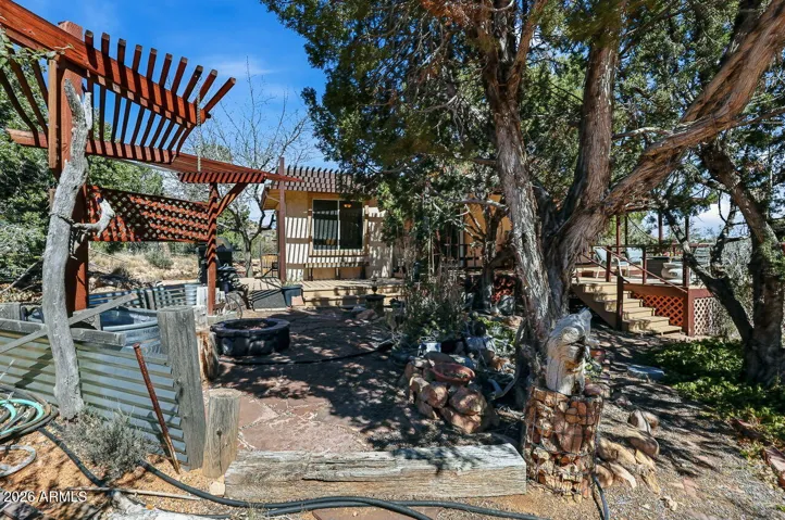 Rustic pergola patio with firepit seating and outdoor gathering space perfect for entertaining under the desert sky.