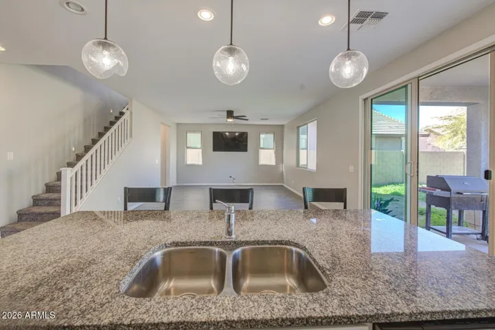 Open concept greatroom features a kitchen with granite countertops, pendant lighting, and kitchen island perfect for daily living and entertaining