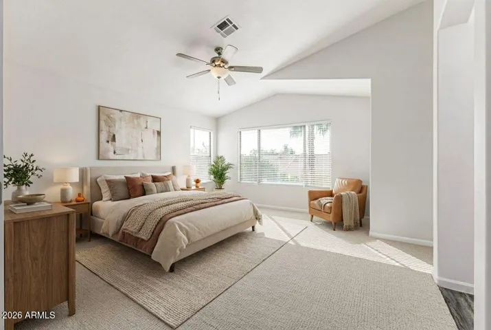 Light-filled primary suite featuring vaulted ceilings, a spacious layout, and a soft neutral palette. Virtually Staged