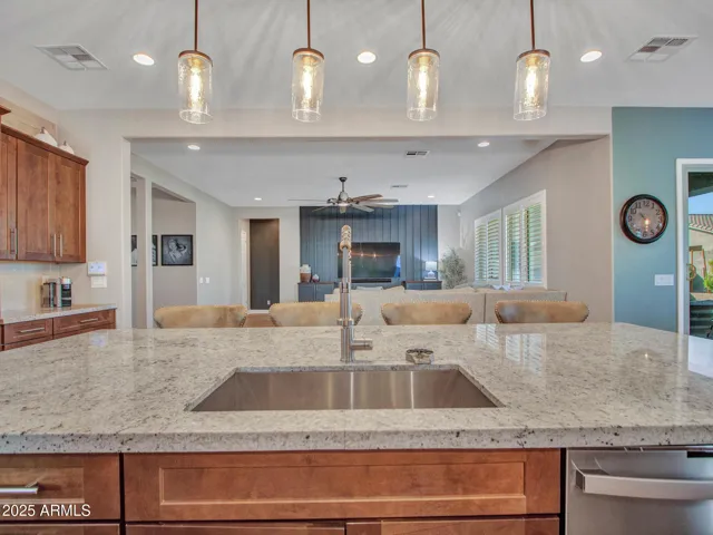 SS farm sink with elegant pendant lighting and sink glass rinser
