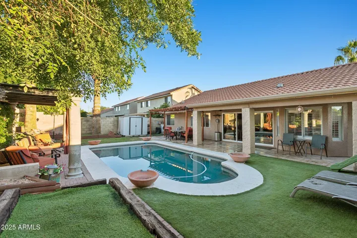 Backyard with turf/covered outdoor sitting area