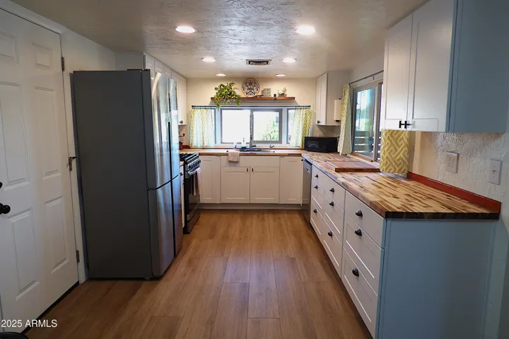 Bright Kitchen with stainless steel appliances & classy cutting board counter tops