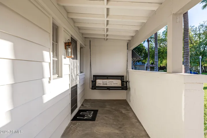 A quaint covered porch has a second entrance on the front of the home. We preserved this fun porch swing so you can hang out and say hey as your neighbors walk by!