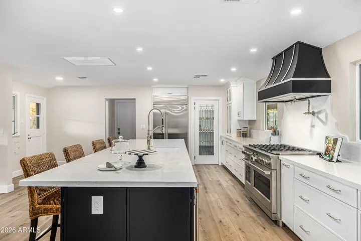 There's so much functional storage here. Deep drawers, custom pullouts, and hidden cabinets on the seating side of the island.