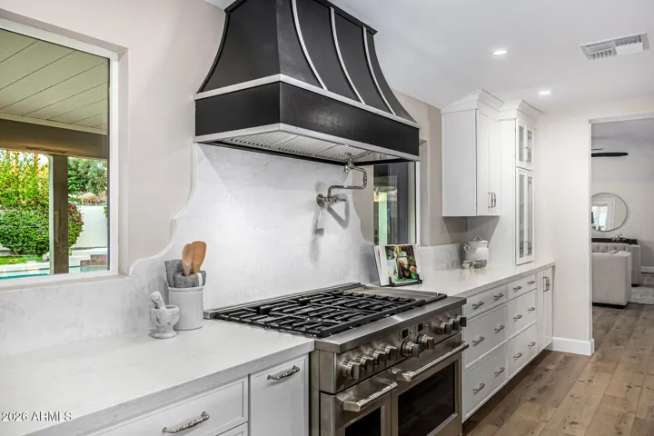 This gorgeous custom-trimmed hood and arabesque backsplash adds a dramatic focal point to the kitchen.