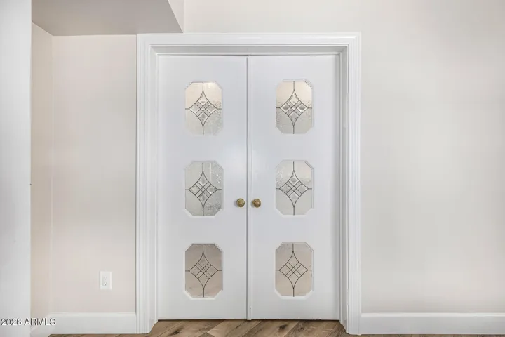 These leaded glass french doors originally separated the dining and sitting rooms. Repurposed here as closet doors in the primary suite, they allow a soft glow of light into the bedroom.