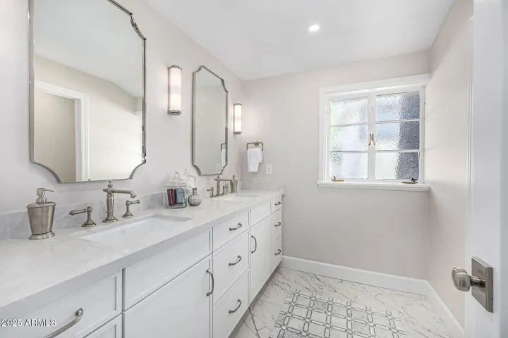 HIstoric styling meets modern luxury! Enjoy a double vanity, toilet closet, and snail shower all finisheshed in elegant marble, neoclassical fixtures, and white cabinetry.