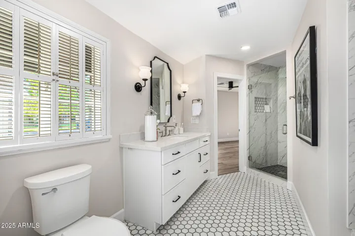 This stunning jack & jill bathroom features classic design elements including original mini-shutters for historic authenticity.