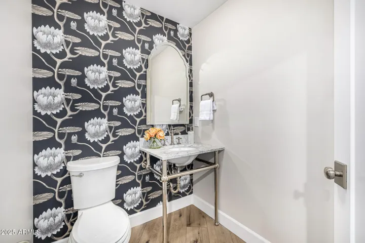 Guests will love this powder room that makes a statement with floral wallpaper and retro fixtures.