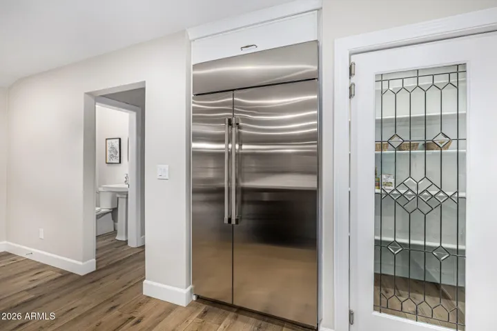 The addition of a built-in fridge and walk-in pantry--featuring a repurposed leaded glass door--lends beauty and practicality to the kitchen.