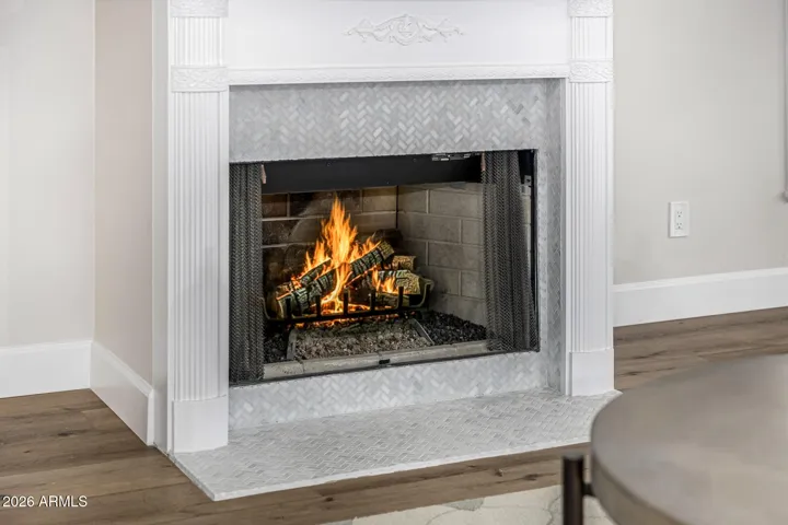 The original wood mantelpiece has been preserved and enhanced with elegant marble facing.