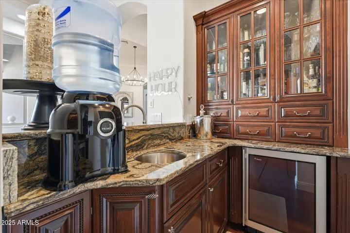 Wet bar off kitchen with sink and beverage fridge