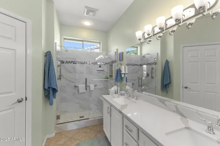 Primary ensuite bathroom from walk-in closet. Private toilet room to the left