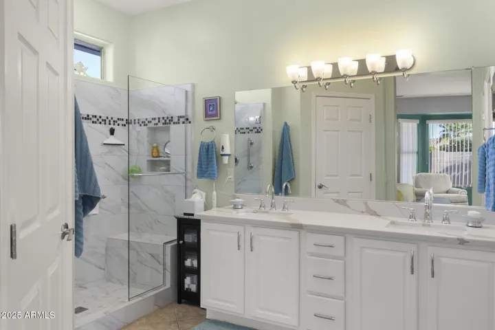 Primary ensuite bathroom with walk in shower, double undermount sinks, quartz tops