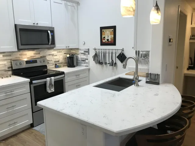 Kitchen is fully stocked with plates, glasses, utensils and cookware