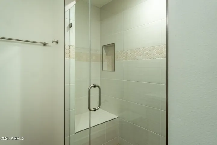 Walk-in shower detailed with soap niche and bench.