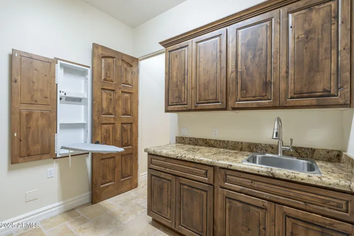 The large laundry room features a sink as well as an ironing center.