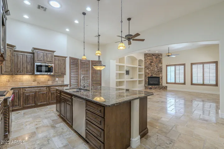 Island featuring double basin stainless sink and dishwasher.
