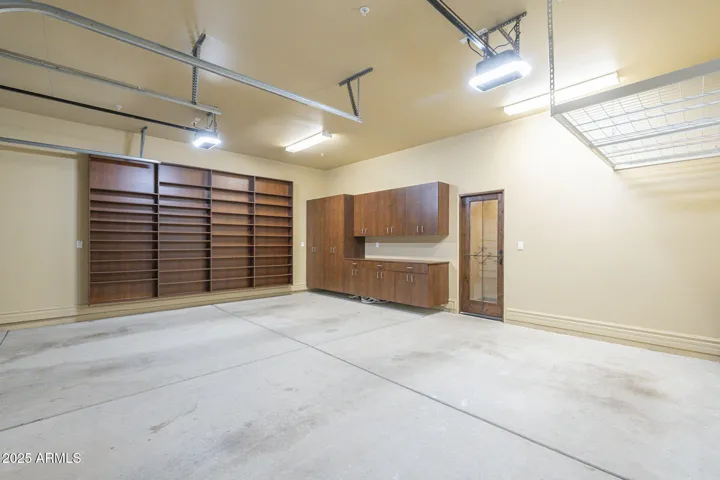 Wine room and built in shelving and cabinets and overhead storage as seen from the 2 separate garage bays. This area is conditioned by a mini-split HVAC