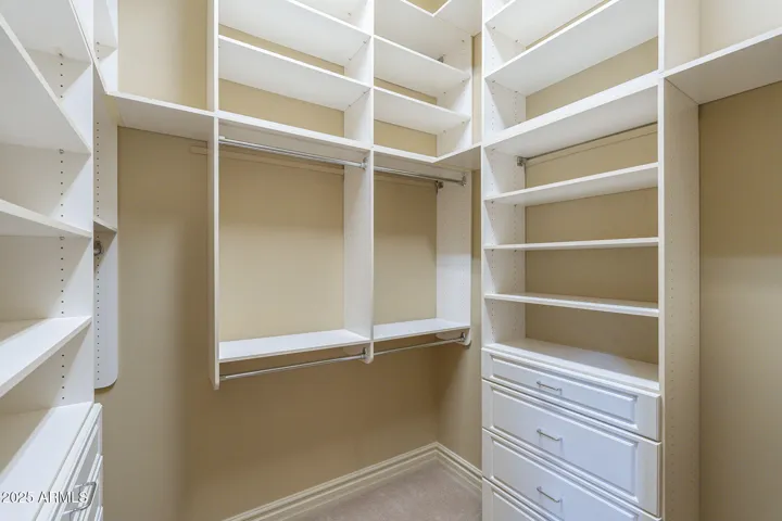 Her closet with built in shelves and drawers.