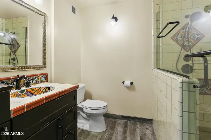 Primary Bathroom; large tiled shower with handmade tile and colorful sink