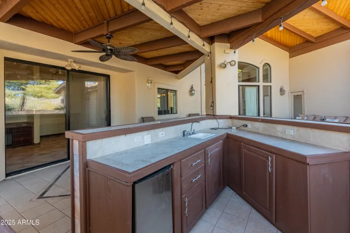 Barbecue cabana featuring mini fridge and gas line for barbecue
