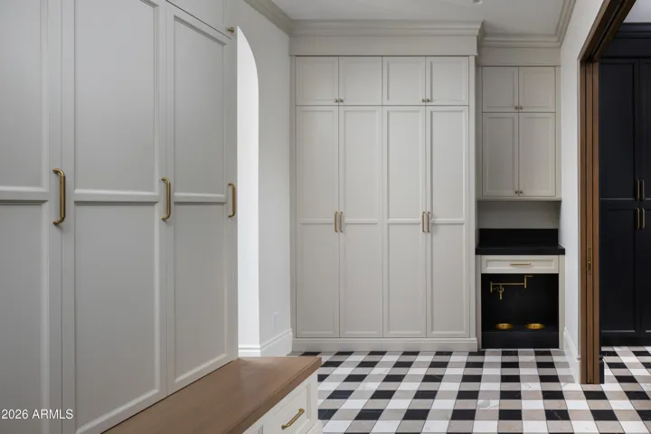 Floor to ceiling custom cabinetry, brass pot filler for paw station, layered in designer touches.