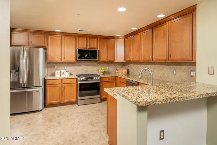 Notice the stainless appliances, granite counters and abundant cabinetry.