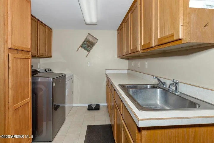 Laundry room is off the garage, with sink and so much storage.