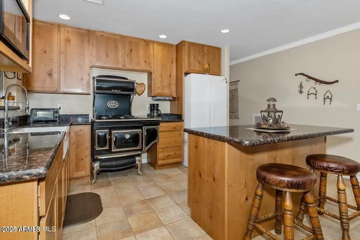 Kitchen has knotty alder cabinetry, granite counters and the stunning retro stove and oven.