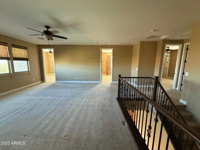 Upstairs living room area with view of entryways to 3 separate bedrooms