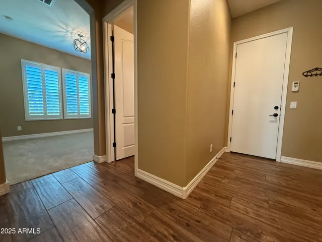 Downstairs hallway that leads to the office, 1/2 bathroom, and garage