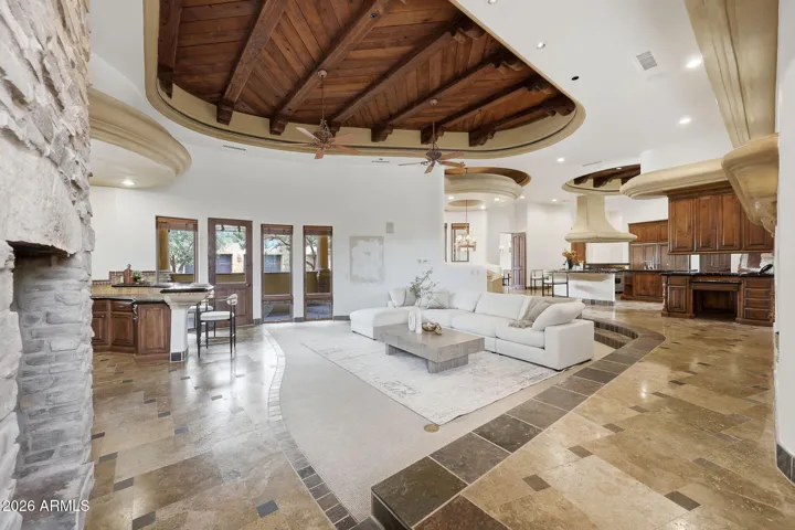 Centered around a floor-to-ceiling stone fireplace with a built-in media wall