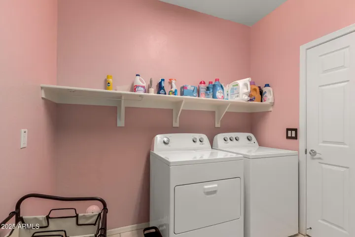 Downstairs laundry room with space for storage or freezer opposite side.